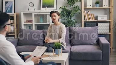 开朗的女人和坐在办公室沙发上的<strong>心理咨询</strong>师交谈